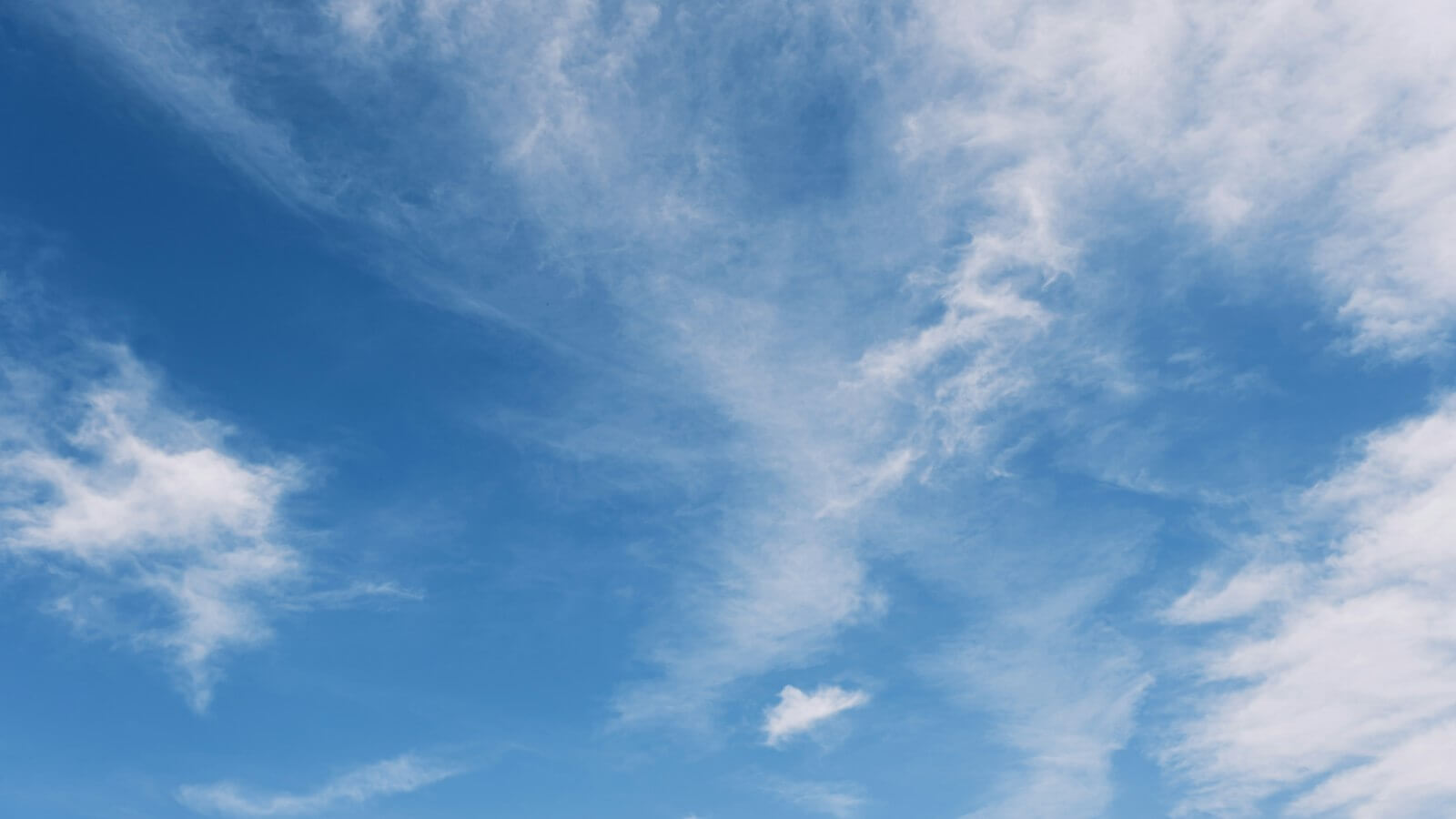 Bright blue sky with thin white clouds